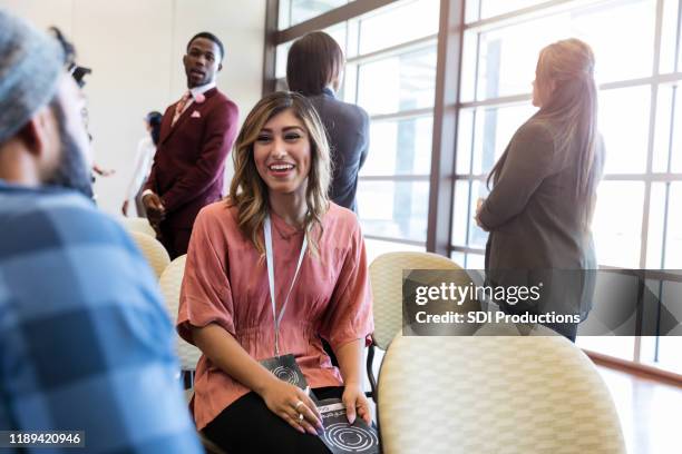 millennials chat during expo or launch event - diverse town hall meeting stock pictures, royalty-free photos & images