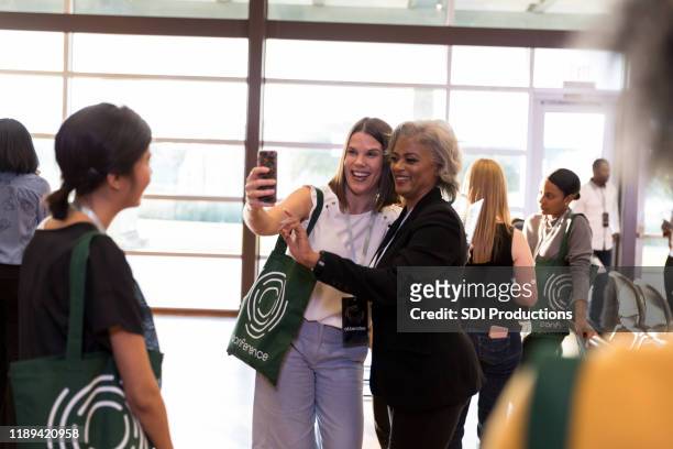 conference attendee takes selfie with conference speaker - kick off call stock pictures, royalty-free photos & images
