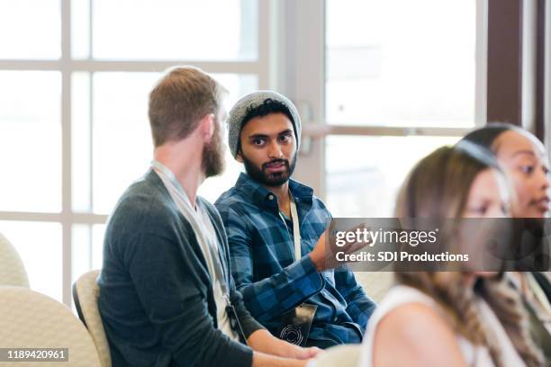 serious male millennial attends conference - town hall meeting stock pictures, royalty-free photos & images