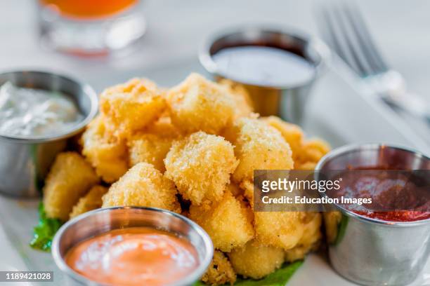 Appetizer of fried cheese curds and dipping sauces.