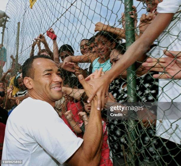 Captain and player for the Brazilian National Soccer team, Cafu, is greeted by residents of the Jardim Irene neighborhood where he was born and...