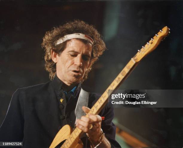 English Rock musician Keith Richards, of the group the Rolling Stones, plays guitar as he performs onstage during the group's 'Voodoo Lounge Tour' at...