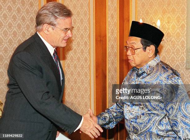Australian Ambassador John McCarthy shakes hands with Indonesian President Abdurrahman Wahid during their meeting at the Presidential Palace in...