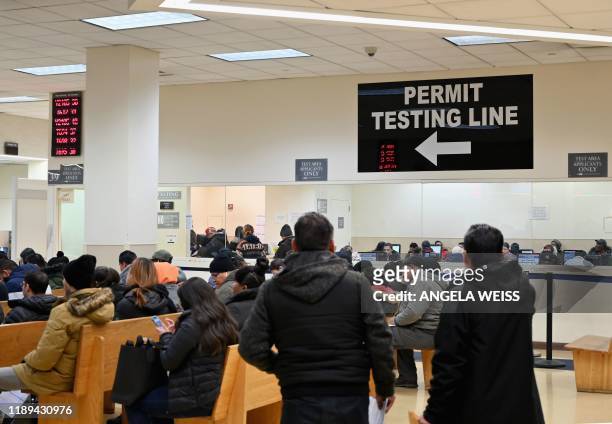 People wait at the New York State Department of Motor Vehicles office at Atlantic Center in the Brooklyn borough of New York on December 18, 2019. -...