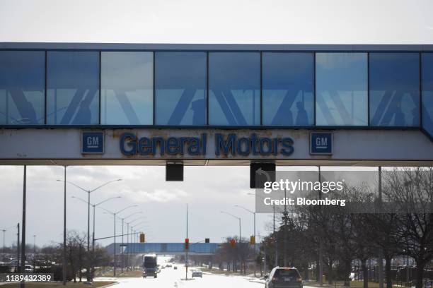 Workers walk along a covered walkway while leaving the General Motors Co. Oshawa assembly plant in Oshawa, Ontario, Canada, on Wednesday, Dec. 18,...