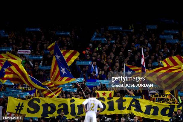 Real Madrid's Spanish defender Dani Carvajal looks at Barcelona's supporters waving Catalan pro-independence "Estelada" flags during the "El Clasico"...