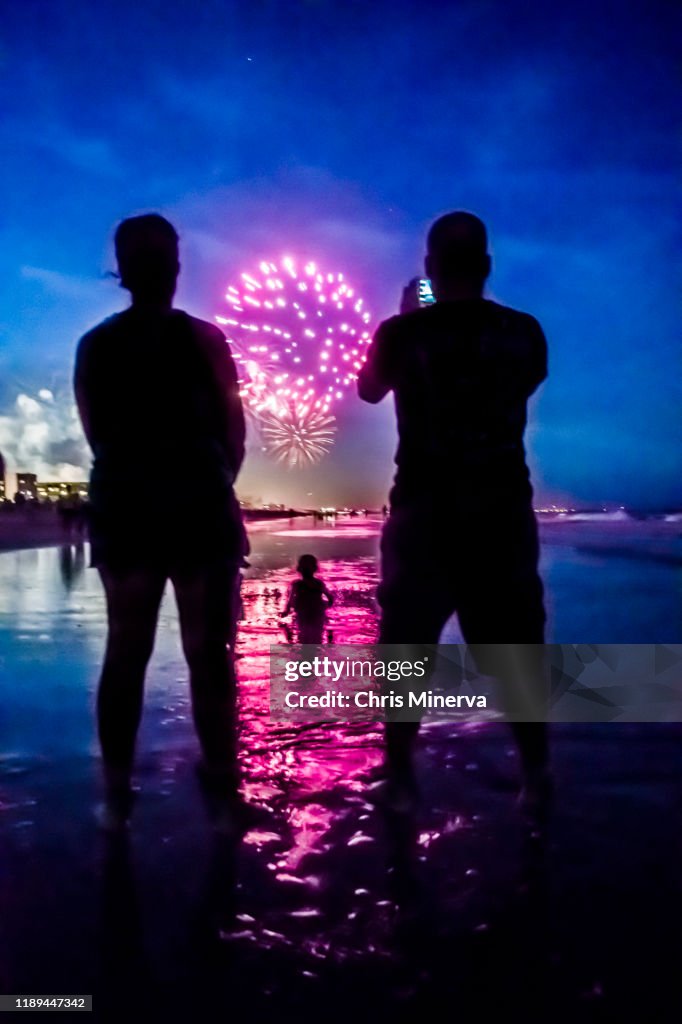 Father Photographs White Firework Display with Mobile Phone