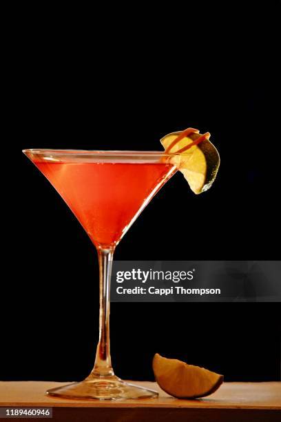 cosmopolitan cocktail over black background - cosmopolitan cocktail stockfoto's en -beelden