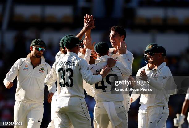 Pat Cummins of Australia celebrates after taking the wicket of Asad Shafiq of Pakistan during day three of the 1st Domain Test between Australia and...