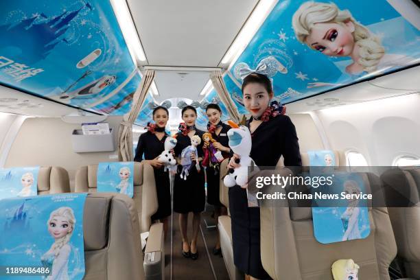 Air hostesses pose for a photo inside Disney Frozen-themed aircraft on November 22, 2019 in Shanghai, China. The China Eastern Airlines plane painted...