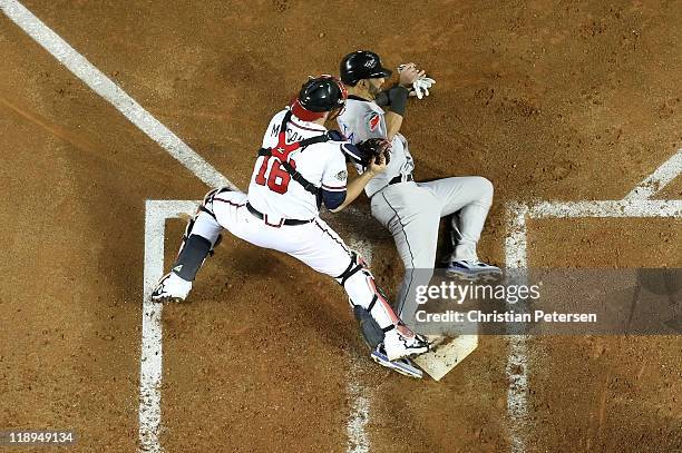 American League All-Star Jose Bautista of the Toronto Blue Jays is tagged out by National League All-Star Brian McCann of the Atlanta Braves on a...