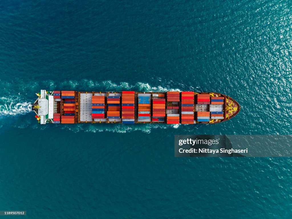 Aerial view of cargo ships in containers sailing in the sea.