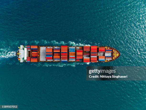 aerial view of cargo ships in containers sailing in the sea. - cargo containers stock pictures, royalty-free photos & images