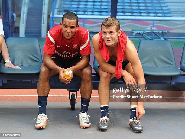 Theo Walcott and Jack Wilshere of Arsenal look on from the touchline during a team training session at the Shah Alam Stadium on July 12, 2011 in Shah...