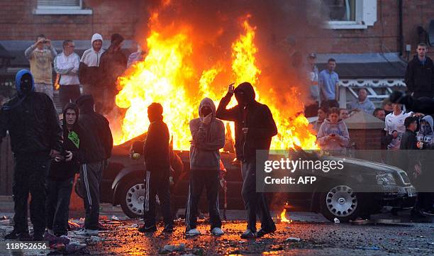 Car is set alight as Nationalist Youths throw rocks and petrol bombs at Police during rioting in Belfast, Northern Ireland, on July 12, 2011. A...