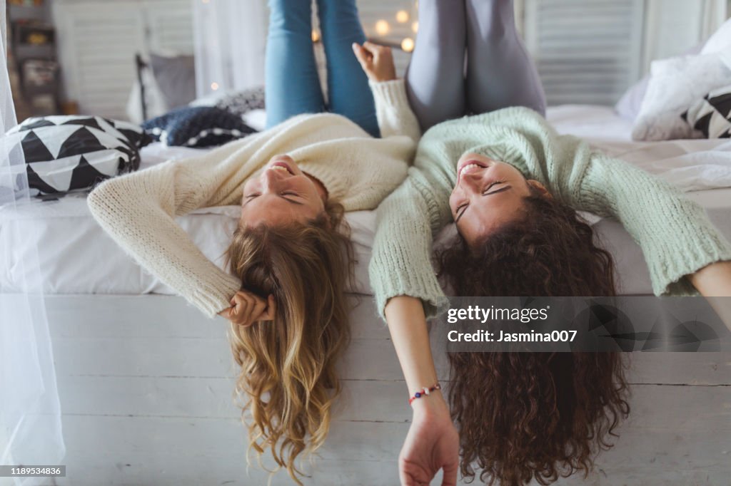 Two young women friends sharing happy time together