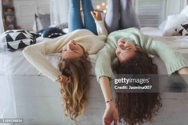 two young women friends sharing happy time together - 2 young woman on couch stock pictures, royalty-free photos & images