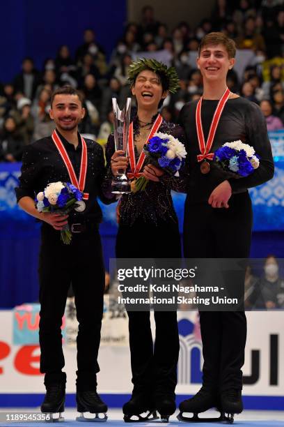 Silver medalist Kevin Aymoz of France, Gold medalist Yuzuru Hanyu of Japan and Bronze medalist Roman Sadovsky of Canada pose for photographs on the...