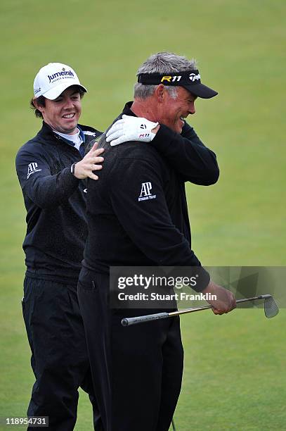 Rory McIlroy and Darren Clarke of Northern Ireland share a laugh during the final practice round during The Open Championship at Royal St. George's...