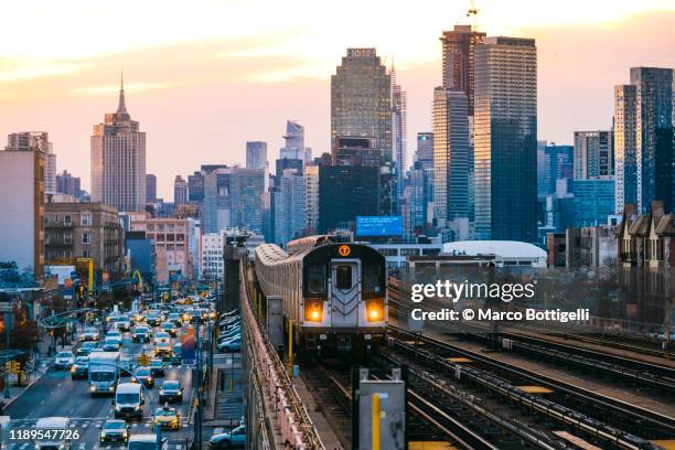 7 line subway train in queens with manhattan skyline, new york city - 地下鉄電車 ストックフォトと画像