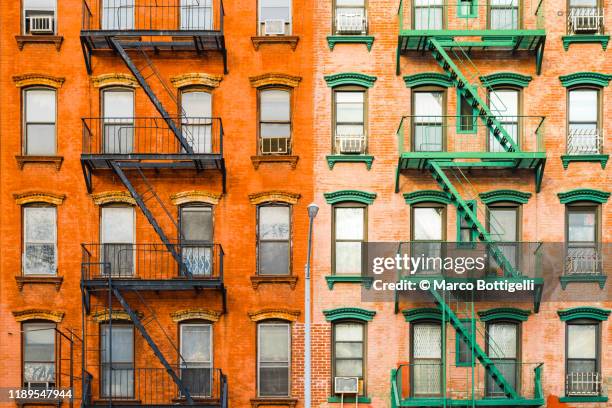 fire escape stairs on typical buildings, new york city - architecture symmetry stock-fotos und bilder