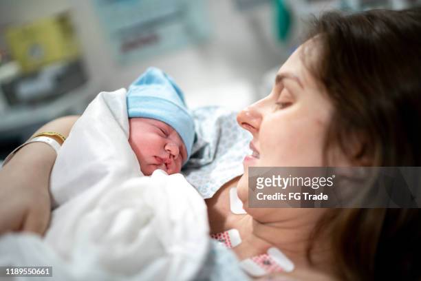 mutter schaut ihr baby zum ersten mal an - kaiserschnitt stock-fotos und bilder