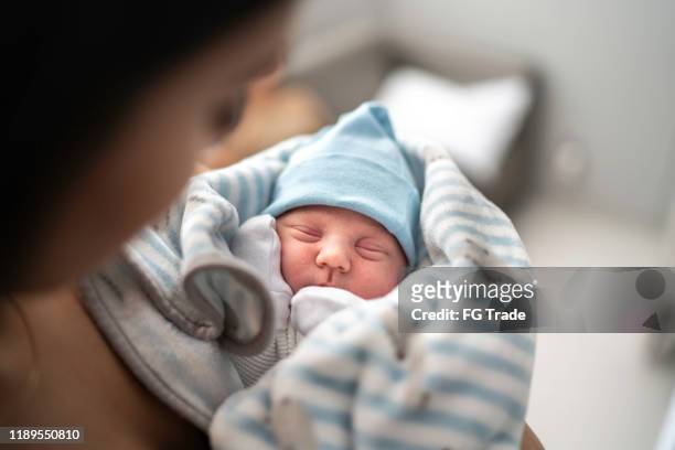 women holding and looking at her godson at hospital - baby stock pictures, royalty-free photos & images