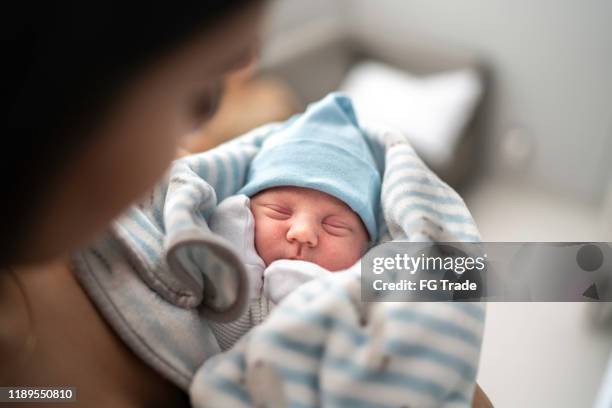 women holding and looking at her godson at hospital - baby hospital stock pictures, royalty-free photos & images