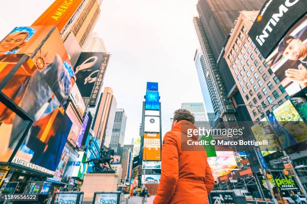 tourist admiring times square, new york city - inserzione pubblicitaria foto e immagini stock