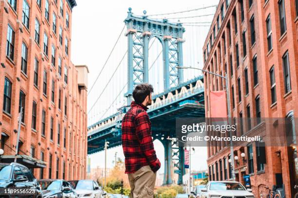 tourist looking at manhattan bridge, new york city - new york tourist stock-fotos und bilder