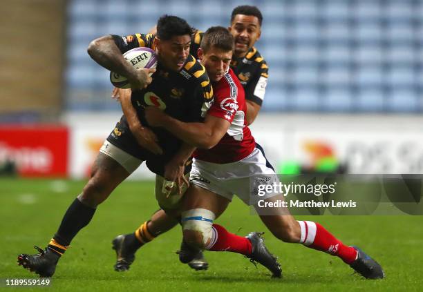 Malakai Fekitoa of Wasps is tackled by Nathan Decron of Agen during the European Rugby Challenge Cup Round 2 match between Wasps and Agen at The...