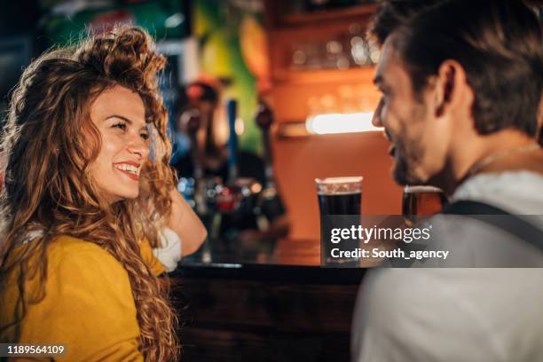 jeunes couples dans le pub - flirter photos et images de collection
