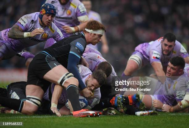 Chiefs player Jonny Hill dives over to score the first Exeter try despite the attentions of Rob Harley of Glasgow as Jack Nowell adds his weight...