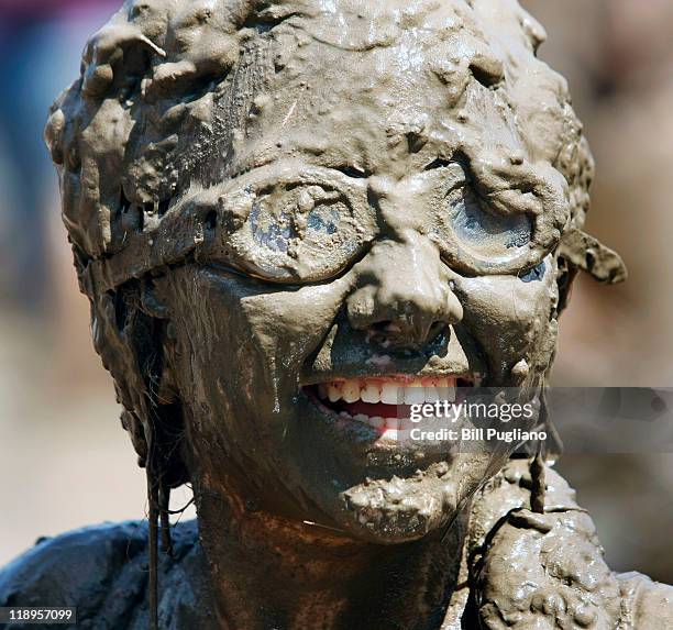 Girl smiles while covered in mud during Wayne County's 2011 Mud Day event at Nankin Mills Park July 12, 2011 in Westland, Michigan. The annual event...