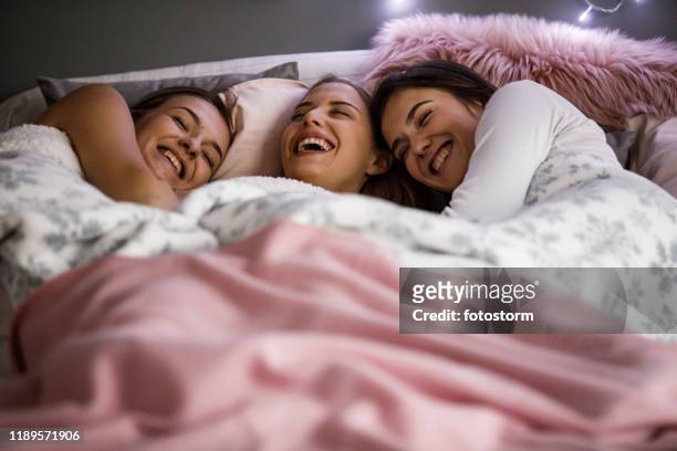 girlfriends having a laugh on a sleepover - college dorm party stock pictures, royalty-free photos & images