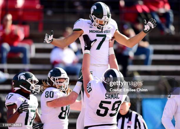 Nick Samac of the Michigan State Spartans lifts up Cody White after his touchdown in the first half of their game against the Rutgers Scarlet Knights...