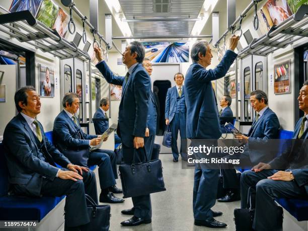 japanische u-bahn-zug von einem mann gefüllt - cloning stock-fotos und bilder