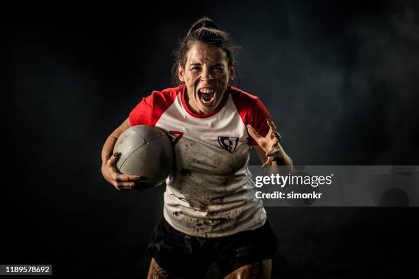 jugadora de rugby femenina sosteniendo el balón - deportistas fotografías e imágenes de stock