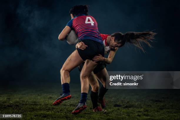 rugby player tackling her opponent - rugby tackling stock pictures, royalty-free photos & images