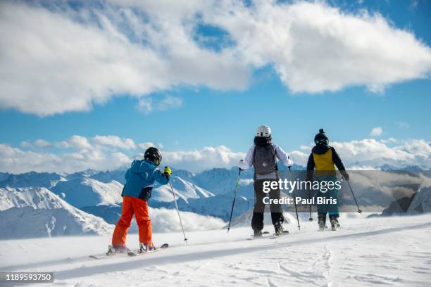 family with two children standing on top of the ischgl silvretta arena ski resort, austria/switzerland - イシュグル ストックフォトと画像