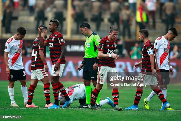 Bruno Henrique of Flamengo reacts agaisnt the Referee Roberto Tobar as Nicolas De La Cruz of River Plate lies on the pitch during the final match of...