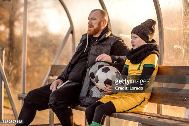 padre de fútbol entrenando hija de fútbol durante un partido - subs bench fotografías e imágenes de stock