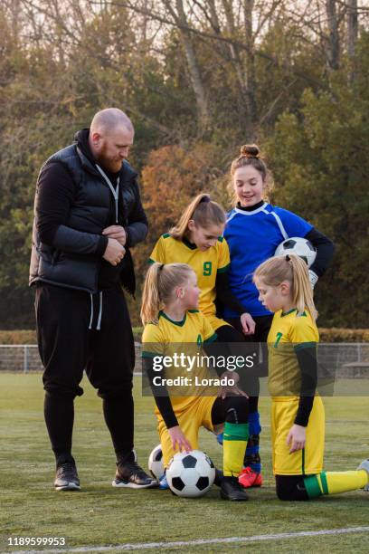 soccer father coaching football daughter's team during a training session - parents sideline stock pictures, royalty-free photos & images