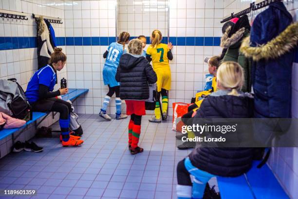 chicas preparándose para un partido de fútbol en un camerino de fútbol - vestuario entre bastidores fotografías e imágenes de stock