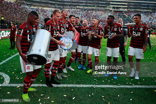 Lincoln, Matheus Dantas and Rafinha of Flamengo sing and play instrument as they celebrate winning the final match of Copa CONMEBOL Libertadores 2019...