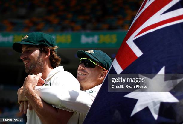 Joe Burns and David Warner of Australia walk out to field during day four of the 1st Domain Test between Australia and Pakistan at The Gabba on...