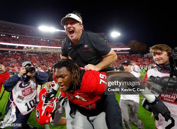 Head coach Kirby Smart of the Georgia Bulldogs leaps on the back of Isaiah Wilson as they celebrate their 19-13 win over the Texas A&M Aggies at...