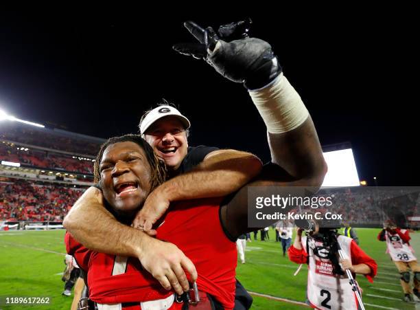 Head coach Kirby Smart of the Georgia Bulldogs leaps on the back of Isaiah Wilson as they celebrate their 19-13 win over the Texas A&M Aggies at...