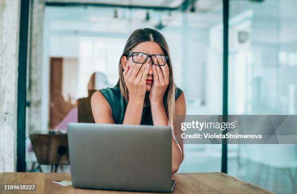 unternehmerin mit kopfschmerzen am schreibtisch sitzen - desk woman glasses stock-fotos und bilder