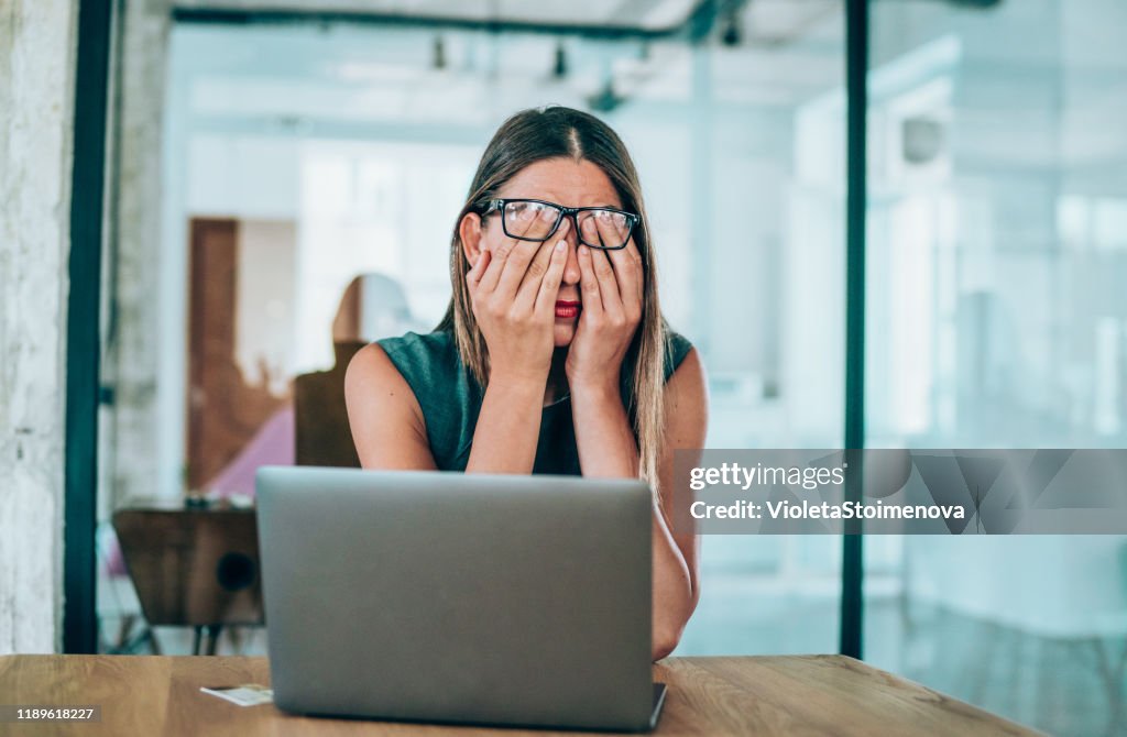 Female entrepreneur with headache sitting at desk